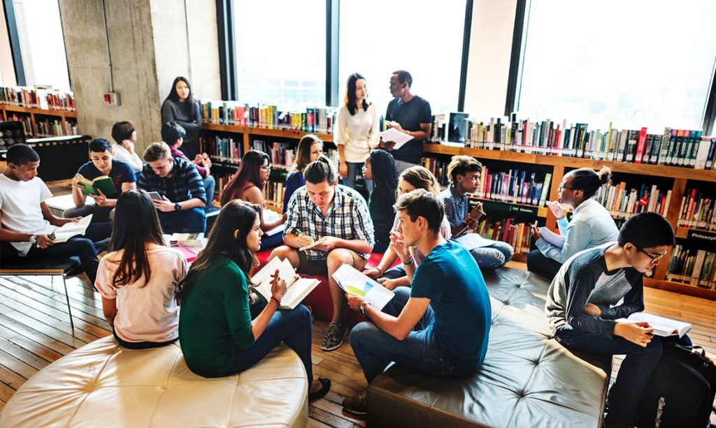 jovens sentados em uma biblioteca