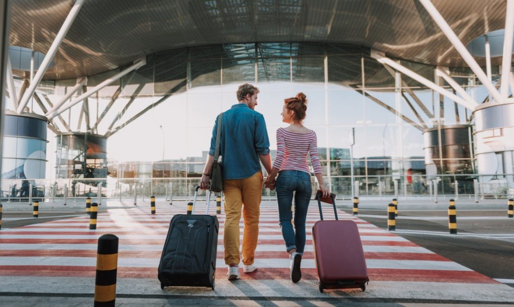 beautiful-loving-couple-with-travel-suitcases-holding-hands-in-picture-id1163153342