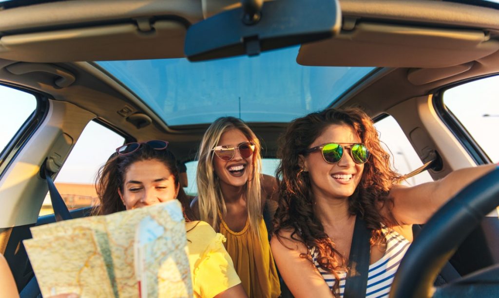 three-female-friends-enjoying-traveling-at-vacation-in-the-car-picture-id1094793968